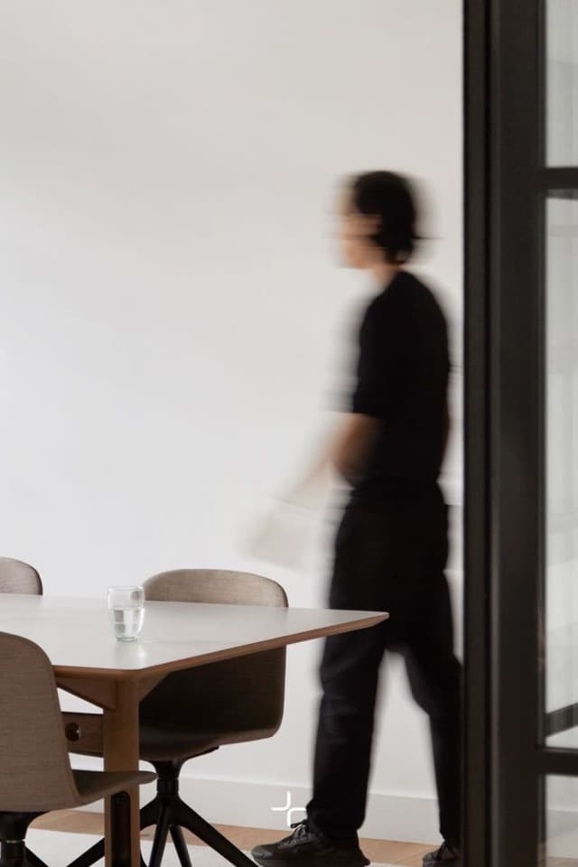 Alguien pasando junto a una mesa de reuniones