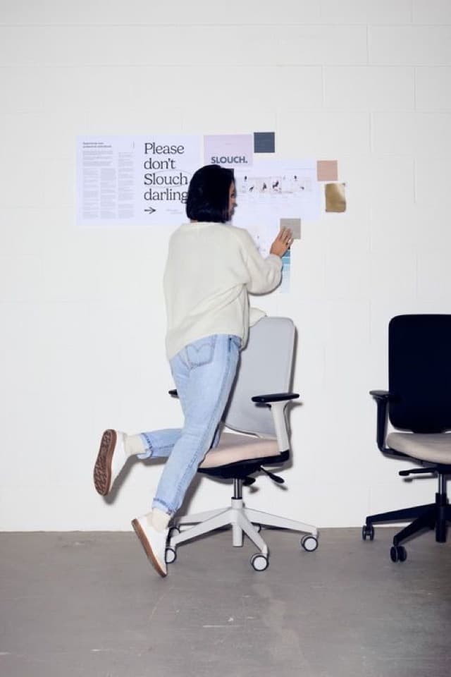 Una mujer pegando notas en la pared de una oficina