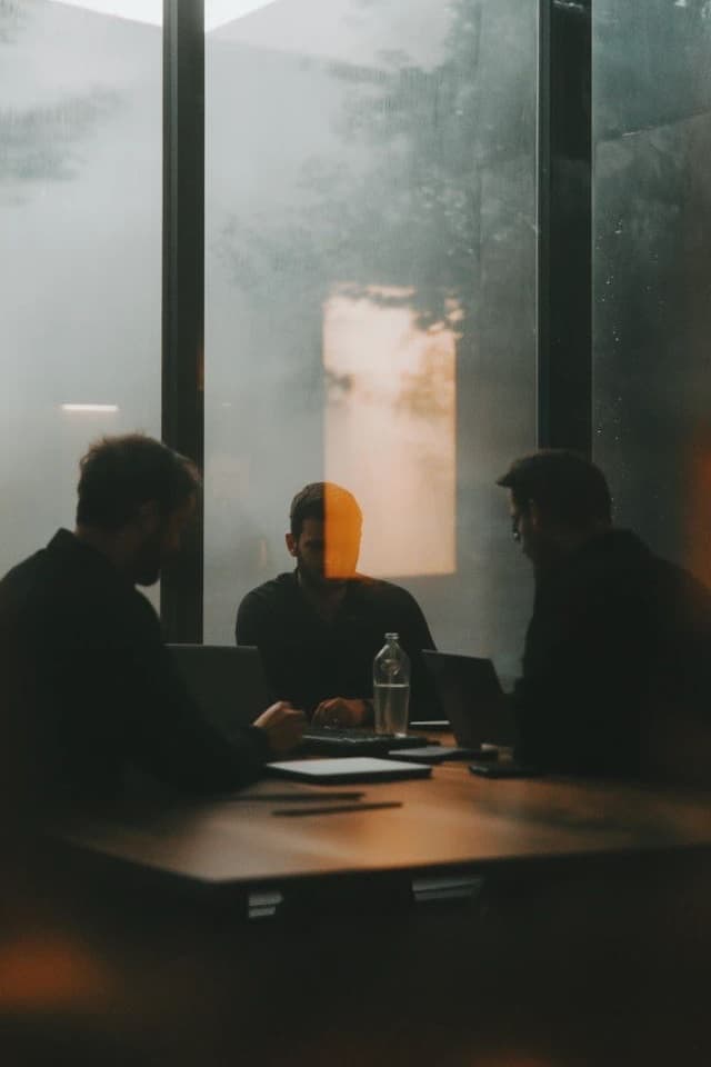 Tres personas reunidas alrededor de una mesa